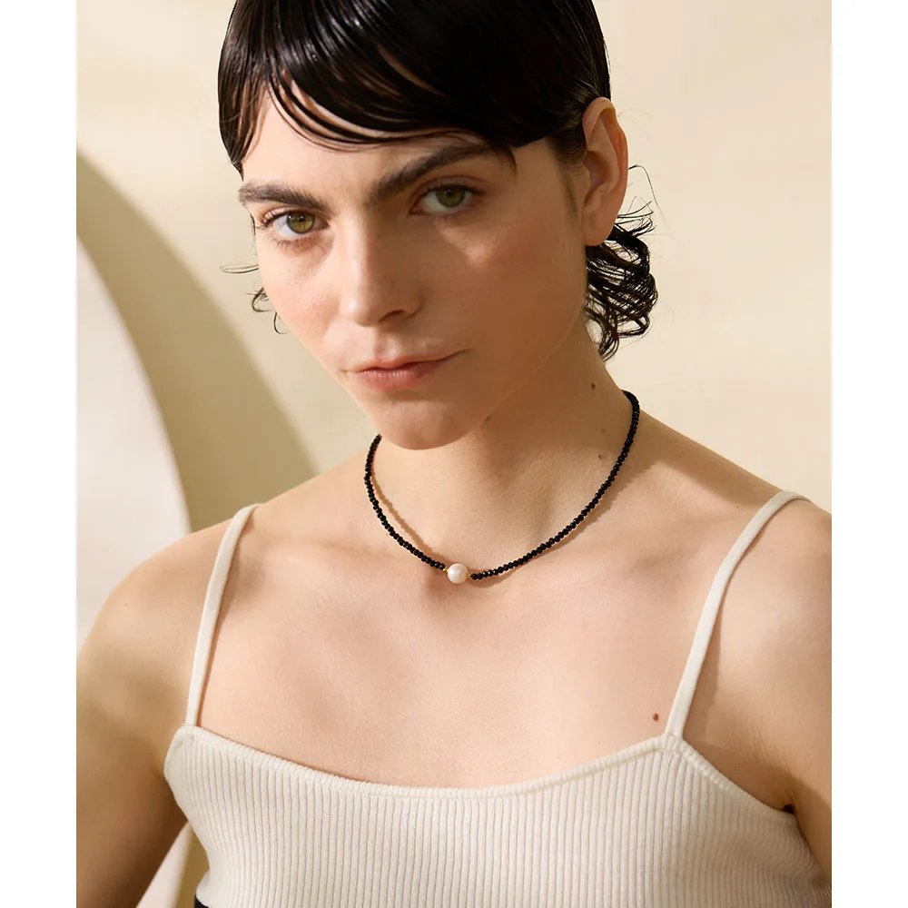 Collier en perles irrégulières noires avec perle blanche unique